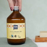 A glass bottle of Fair Squared Fairtrade Vanilla Shower Gel 500ml in a bathroom - vegan, cruelty free and plastic free - for sale at Babipur.