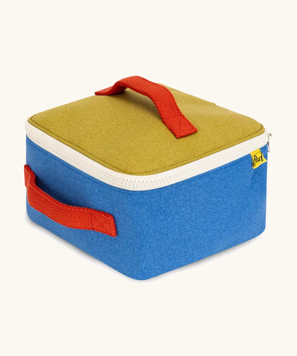 Side of a Fluf GOTS organic cotton square lunch bag in a blue with green top panel showing the white zip detail and red carry handles