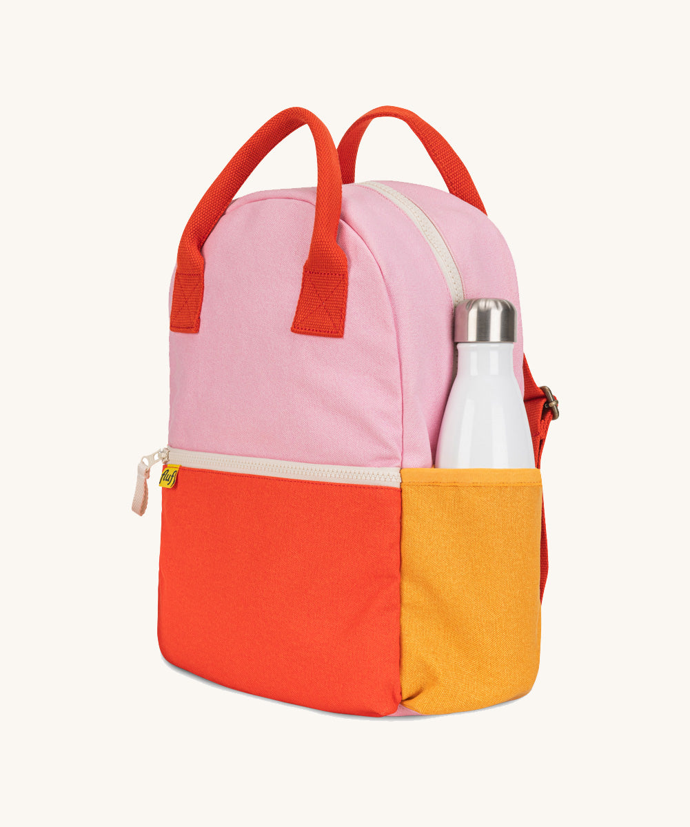 A side view of The organic cotton Fluf B-Pack Jr, a kids school backpack with a drink holder side pocket