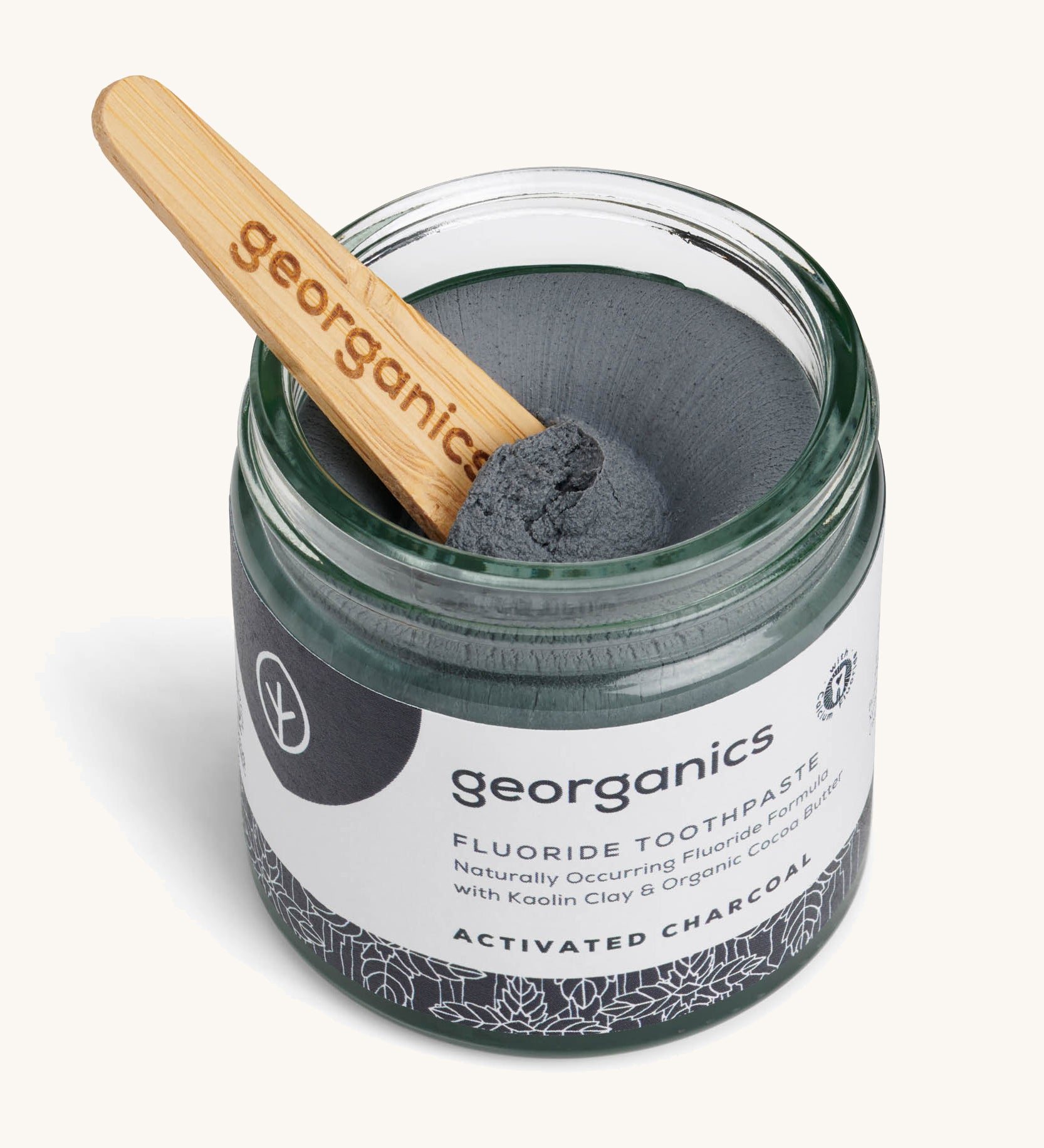 A opened jar of the activated fluoride Georganics toothpaste with the wooden spatula dipped in the jar