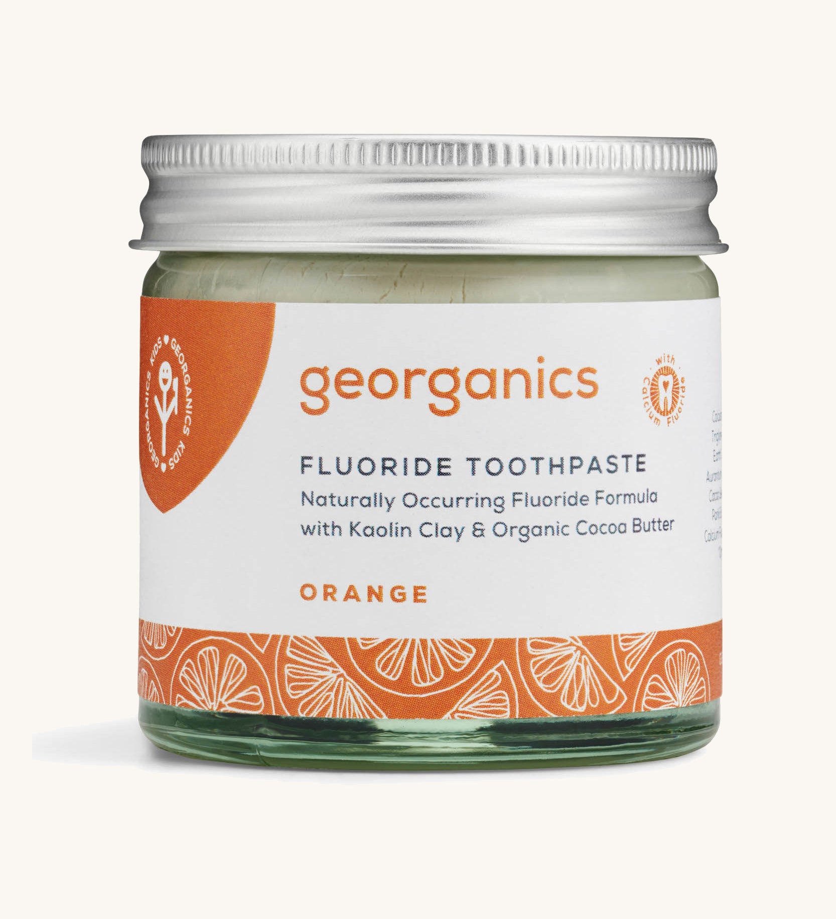 a jar of the Georganics orange fluoride toothpaste on a cream background