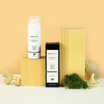 The Green People Nordic Roots Truffle Night Cream and its box is on a yellow background with the cream tube on a wooden block, with moss and mushrooms surrounding 