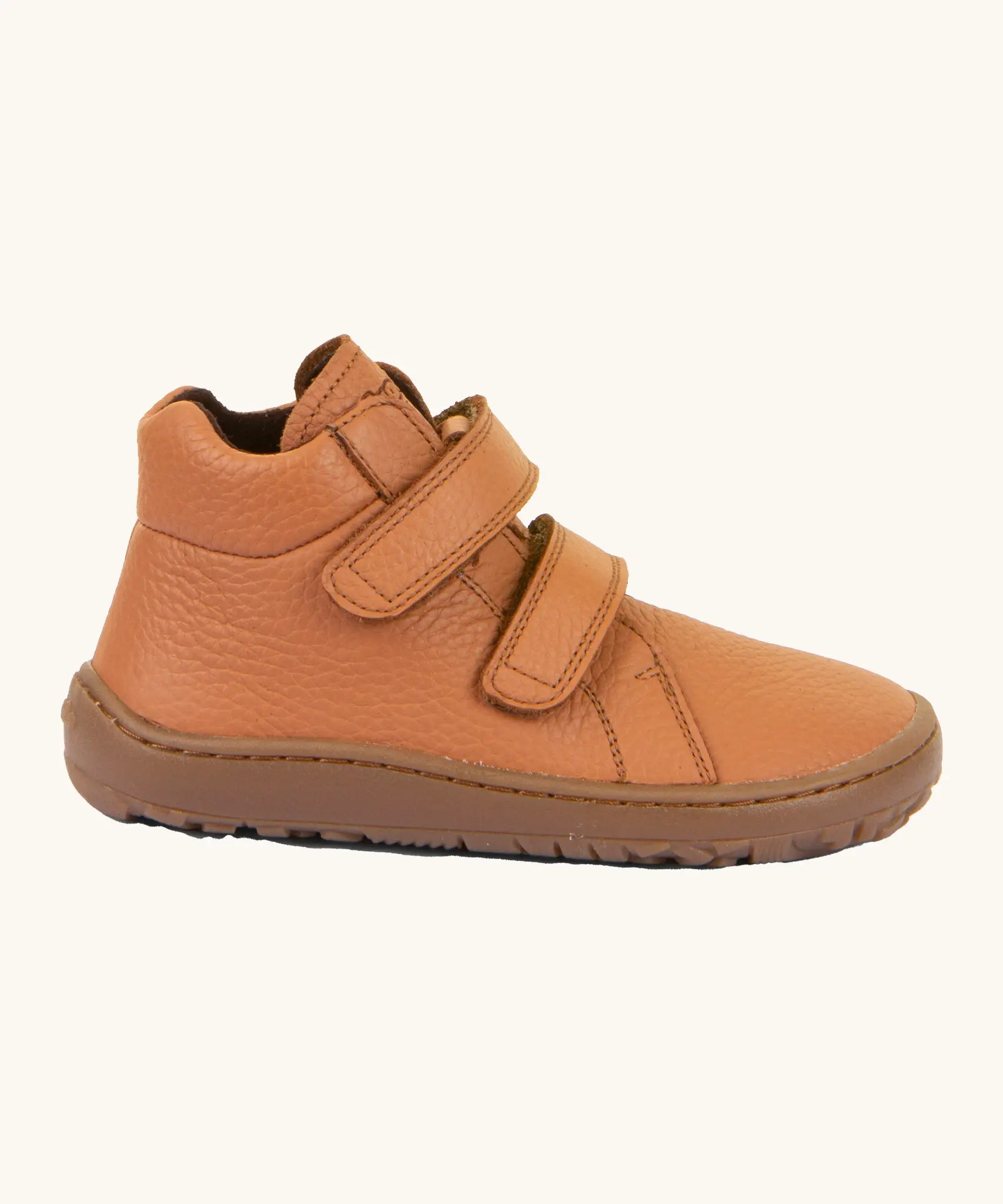Side of  Froddo's natural leather kids barefoot shoe in rusty brown showing the padded ankle support and flexible rubber sole. Shoe has a zero-drop profile