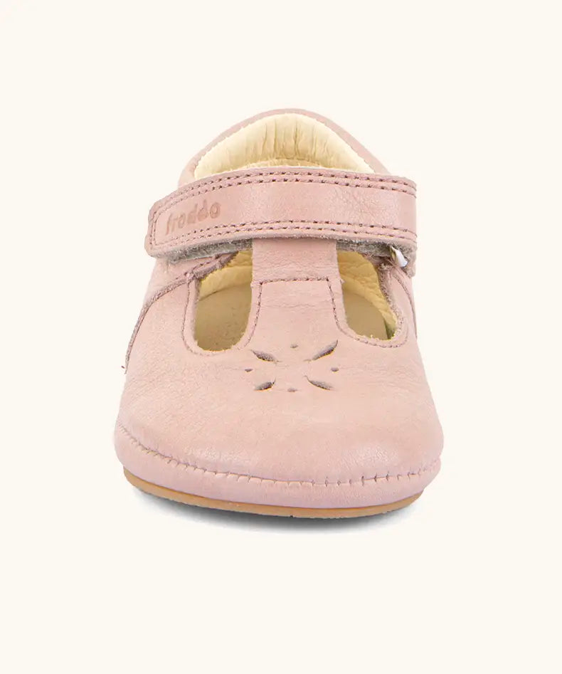 Front of Froddo barefoot walker baby shoe in pink. A natural leather shoe with a velcro t bar strap and flower cut out on toe