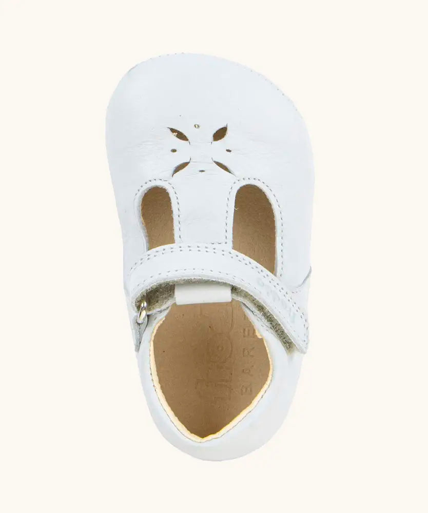 Froddo barefoot baby pre walker shoe in white. A natural leather shoe with a velcro t bar strap and flower cut out on front