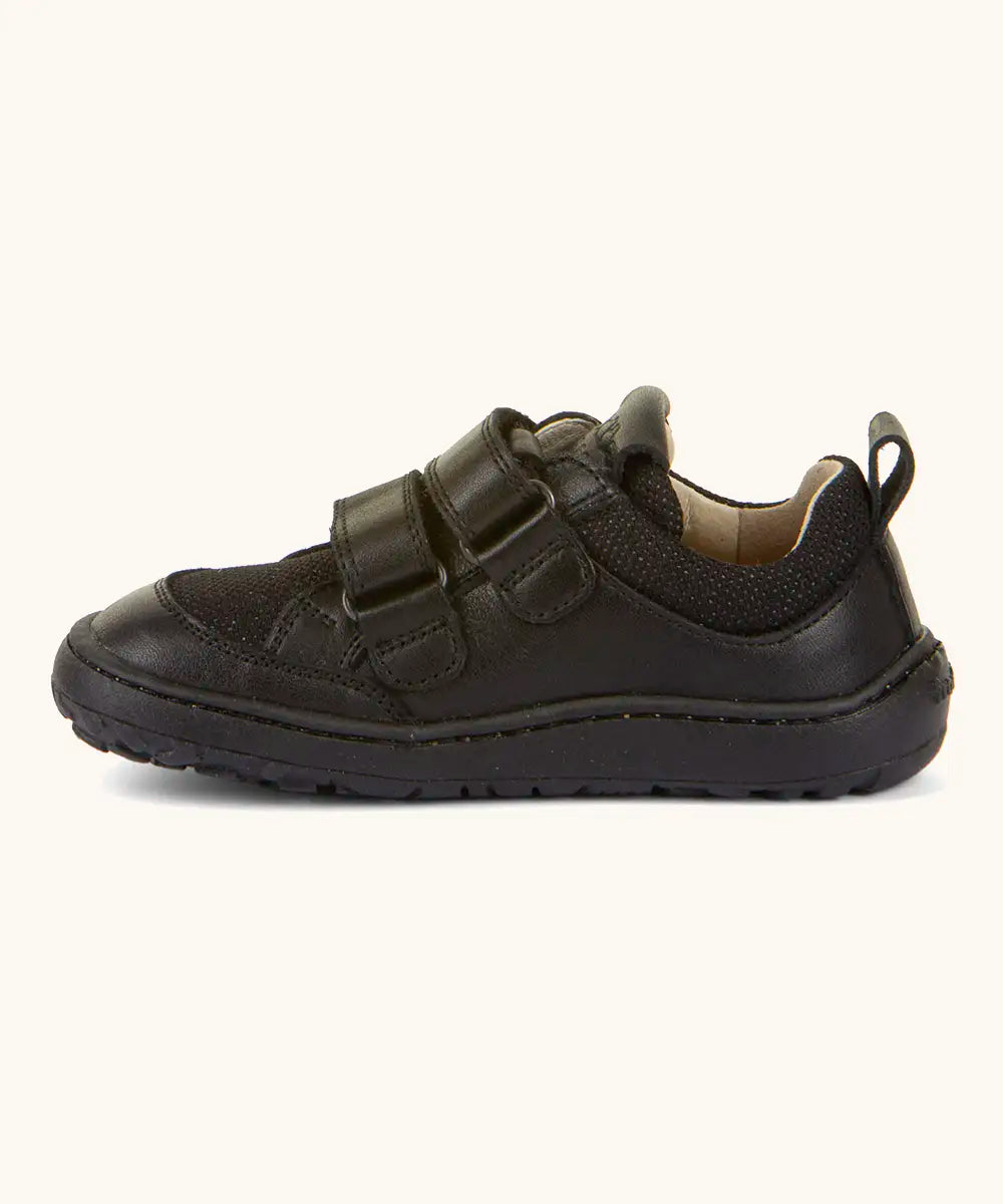 Side of Froddo barefoot low profile children's shoe in black showing 2 velcro fasteners looped through eyelets