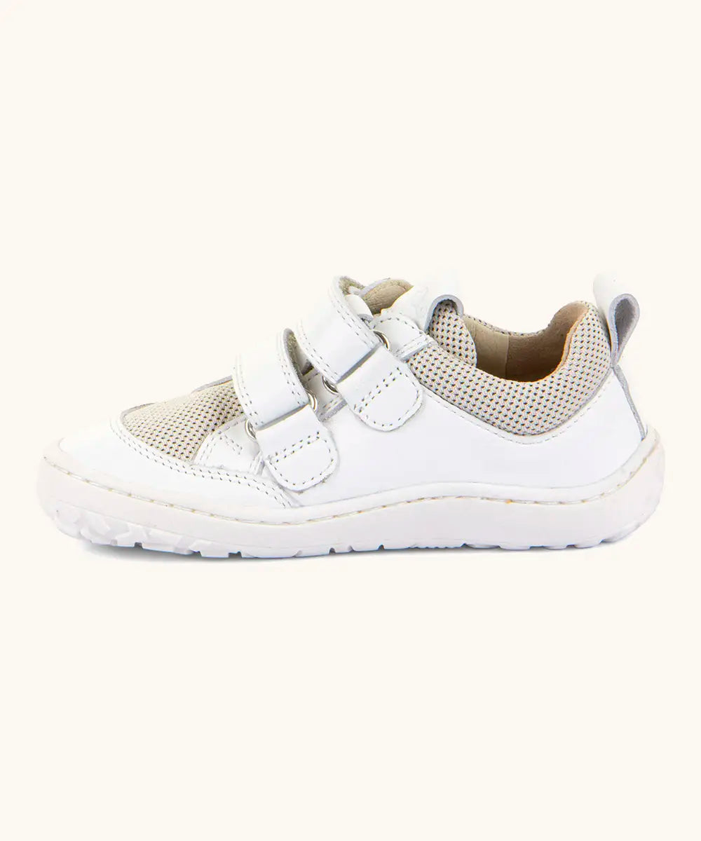 Side of Froddo barefoot low profile children's shoe in white showing 2 velcro fasteners looped through eyelets