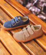 A blue and beige Froddo barefoot botaniq canvas style shoe standing on a wooden bench