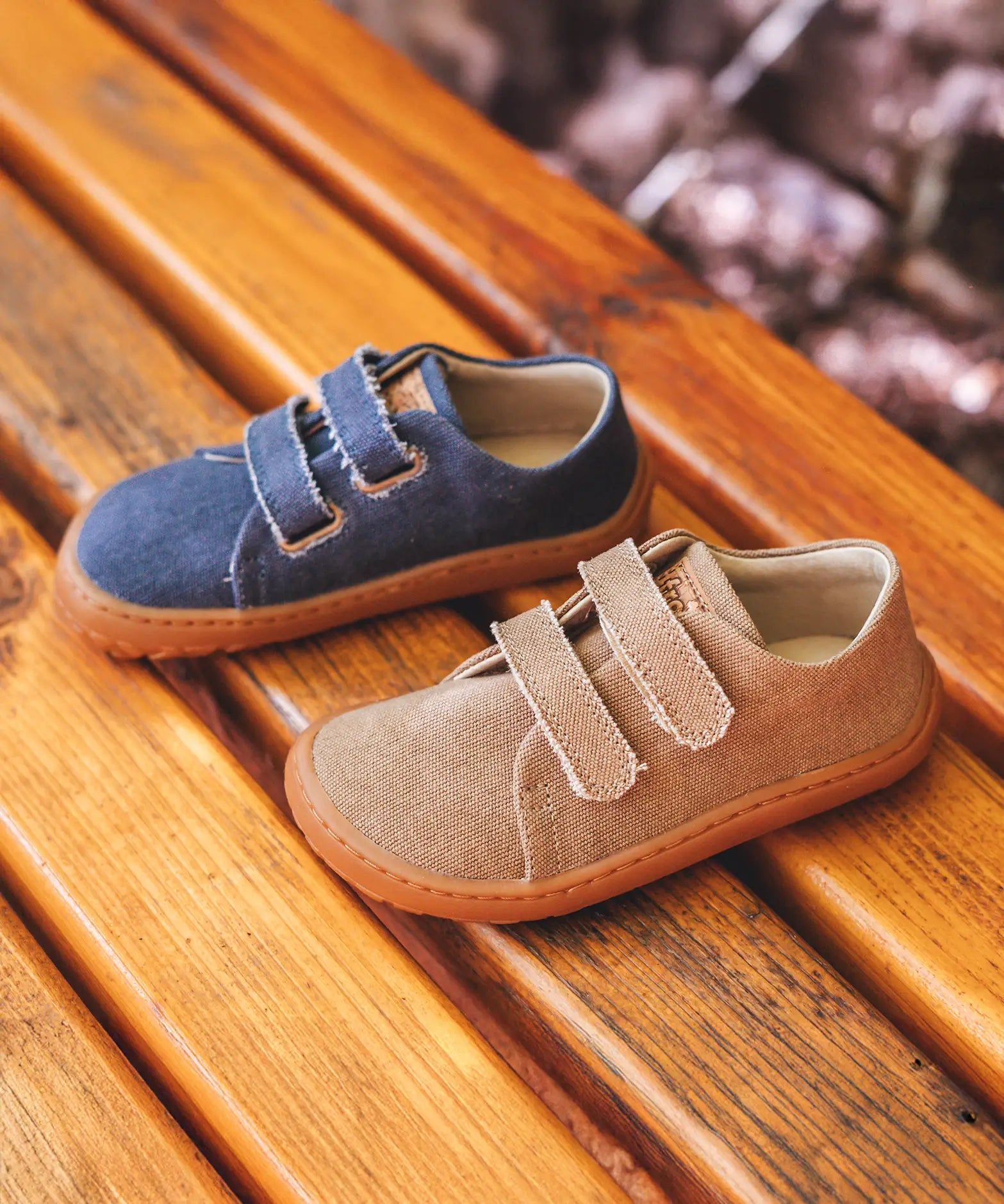 A blue and beige Froddo barefoot botaniq canvas style shoe standing on a wooden bench