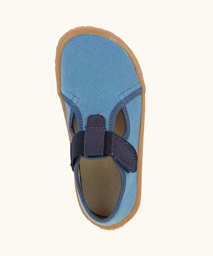 Top view of Froddo barefoot canvas style kids shoes in light blue with  showing contrast t-bar velcro looped through the eyelet 