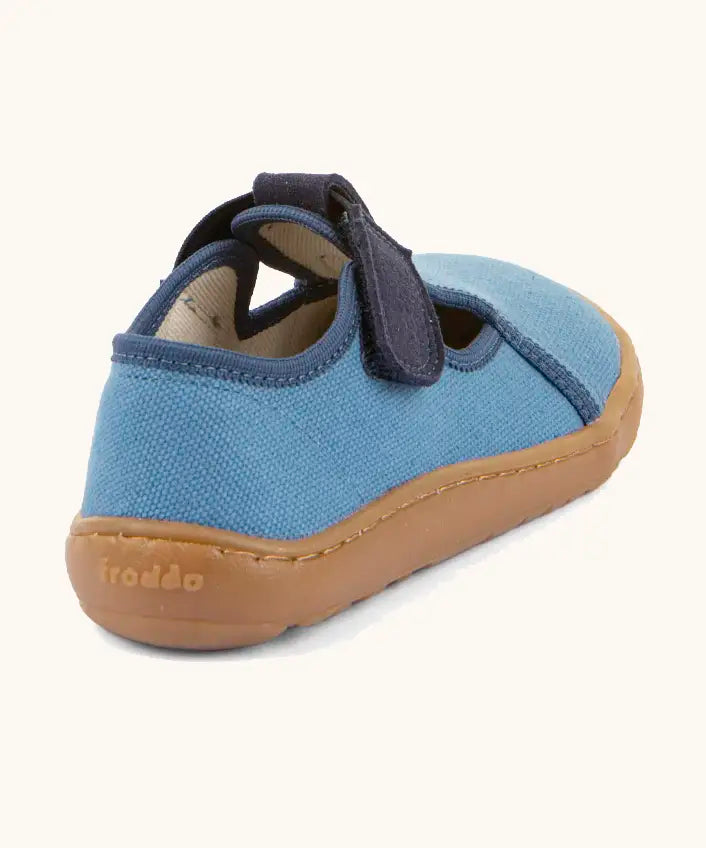 Back of Froddo barefoot canvas style kids shoes in light blue with a contrast t-bar velcro fastener and brown rubber sole