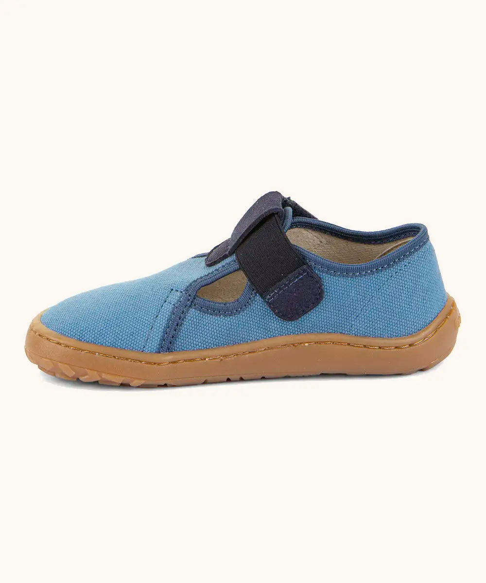 Side of Froddo barefoot canvas style kids shoes in light blue showing t-bar velcro fastener lopped through the eyelet 