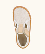 Top view of Froddo barefoot canvas style kids shoes in pale cream with  showing t-bar velcro fastener lopped through the eyelet 