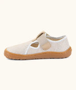 Side of Froddo barefoot canvas style kids shoes in pale cream  showing t-bar velcro fastener lopped through the eyelet 