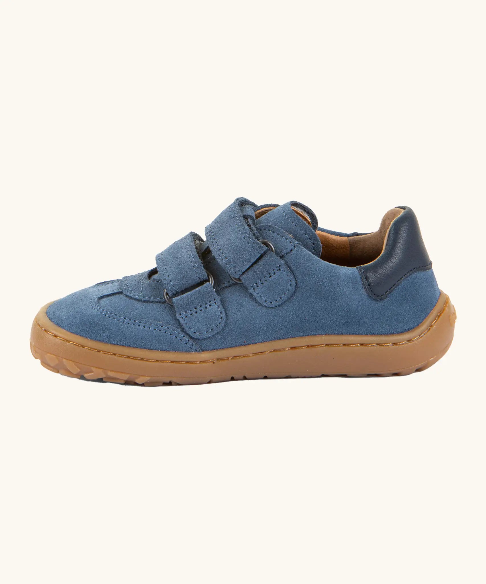Side of Froddo's barefoot f-motion kids suede shoes in denim blue showing the velcro fasteners looped through the eyelets 