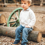 Child sitting on a log and wearing Froddo’s Barefoot Kids F-Motion TEX Shoes in dark blue