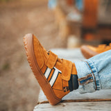 Child wearing Froddo’s Barefoot Kids F-Motion TEX Shoes in mustard with the velcro fully fastened. Boot sits around the upper ankle