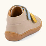 Back of the Froddo barefoot first step baby shoe in beige showing a padded ankle support and grippy sole 