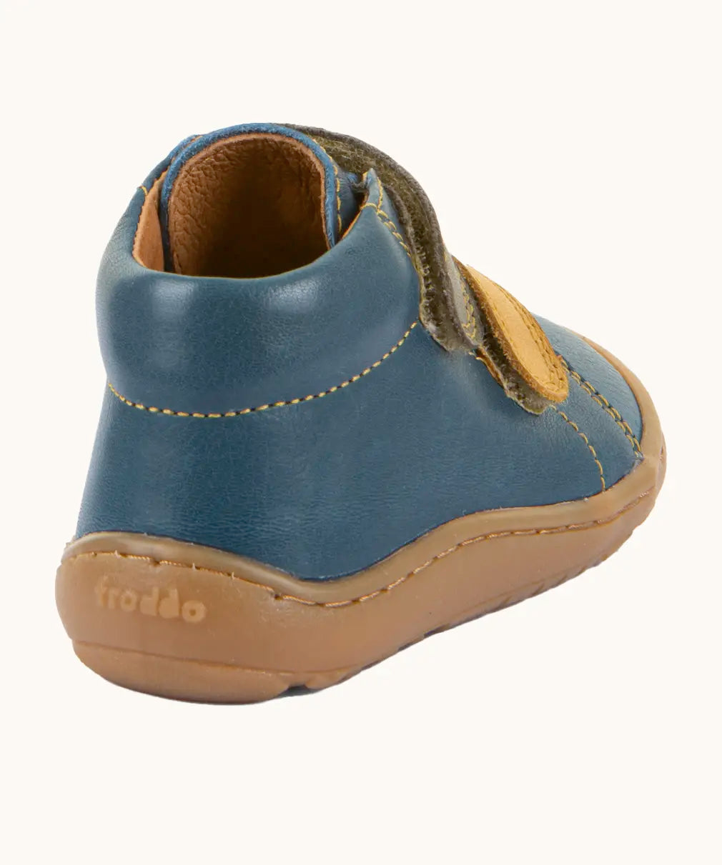 Back of Froddo's denim blue natural leather barefoot first step kids shoes showing the padded ankle support. Boot has a zero drop profile
