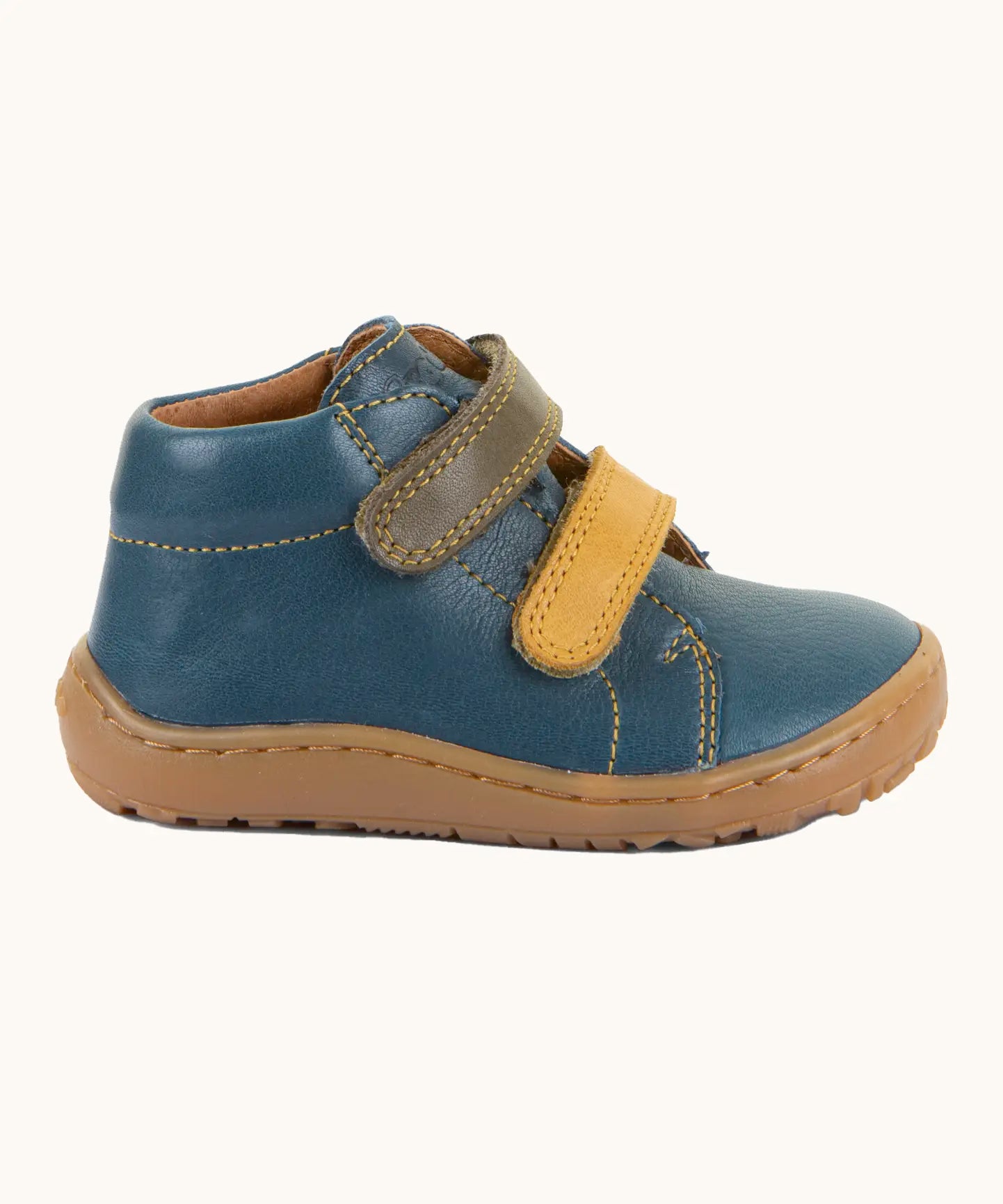Side of Froddo's light brown natural leather barefoot first step kids shoes showing the velcro straps fastened. Boot has a flexible rubber sole zero-drop profile