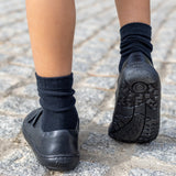 Back of child wearing Froddo's natural black leather barefoot school shoes showing the tread detail on the sole