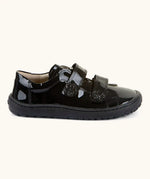 Side of Froddo barefoot kids school shoe in black patent. A low profile shoe with 2 front velcro straps with a decoration on the end