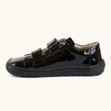 Side of Froddo Alexandra barefoot kids school shoe in black patent showing the velcro straps looped through the eyelets