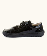 Side of Froddo Alexandra barefoot kids school shoe in black patent showing the velcro straps looped through the eyelets