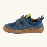 Side of Froddo's denim blue barefoot baze kids shoes showing the velcro straps looped through the eyelets. Trainer has a zero heel drop design 