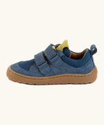 Side of Froddo's denim blue barefoot baze kids shoes showing the velcro straps looped through the eyelets. Trainer has a zero heel drop design 