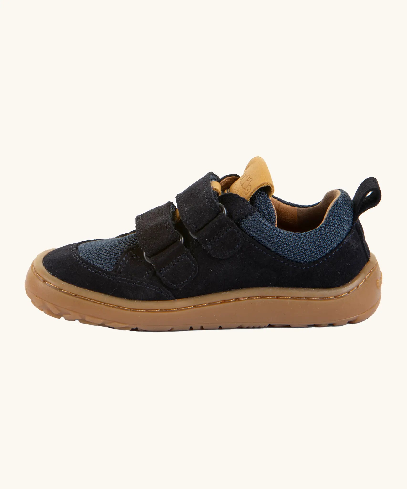Side of Froddo's navy blue barefoot baze kids shoes showing the velcro straps looped through the eyelets. Trainer has a zero heel drop design 