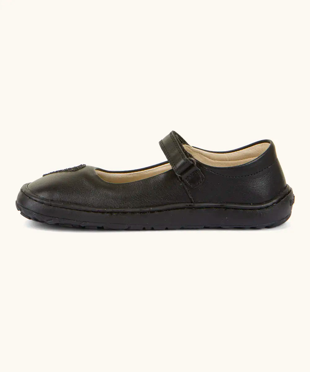 Side of Froddo barefoot kids natural black leather school shoe showing velcro strap looped through the eyelet