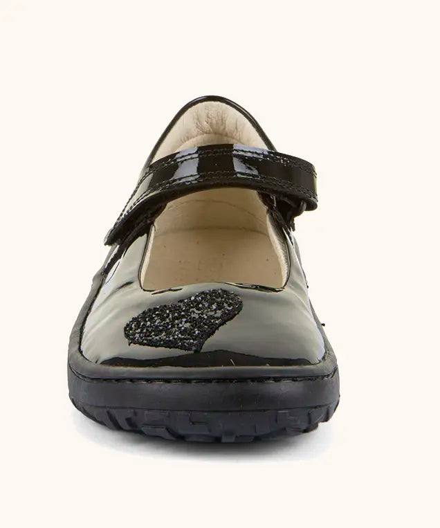 Front of Froddo barefoot kids black patent school shoe. A dolly shoe with a heart decoration on the front