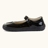 Side of Froddo barefoot kids in black patent school shoe showing velcro strap looped through the eyelet