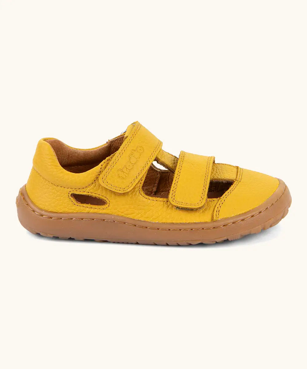 Side of  Froddo's natural leather barefoot children's sandal in yellow showing 2 velcro fasteners and a brown rubber sole