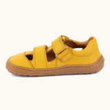 Froddo barefoot children's sandal in yellow showing a velcro fasteners looped through the eyelet and a brown rubber sole