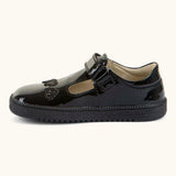 Side of Froddo barefoot kids school shoe in black patent material showing t-bar velcro fastener looped through eyelet