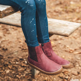 Child wearing Froddo's barefoot kids leather chelsea boot in maroon. Boots sit above the ankle and have a zip fastener