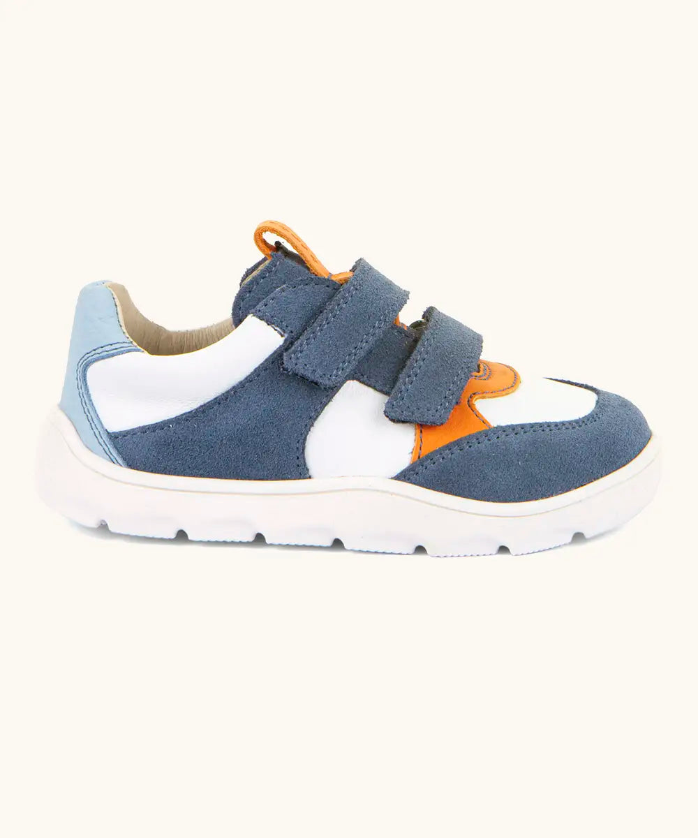 Side of Froddo barefoot zeru Spring kids shoes in blue and white. Showing 2 blue velcro fasteners, pull tab on tongue and white grippy sole