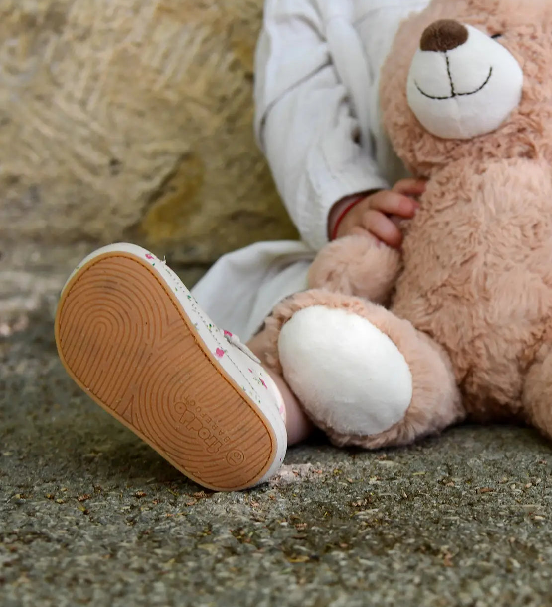 Close up of child wearing small child wearing Froddo's natural leather pre walker sandals showing rubber sole detail 