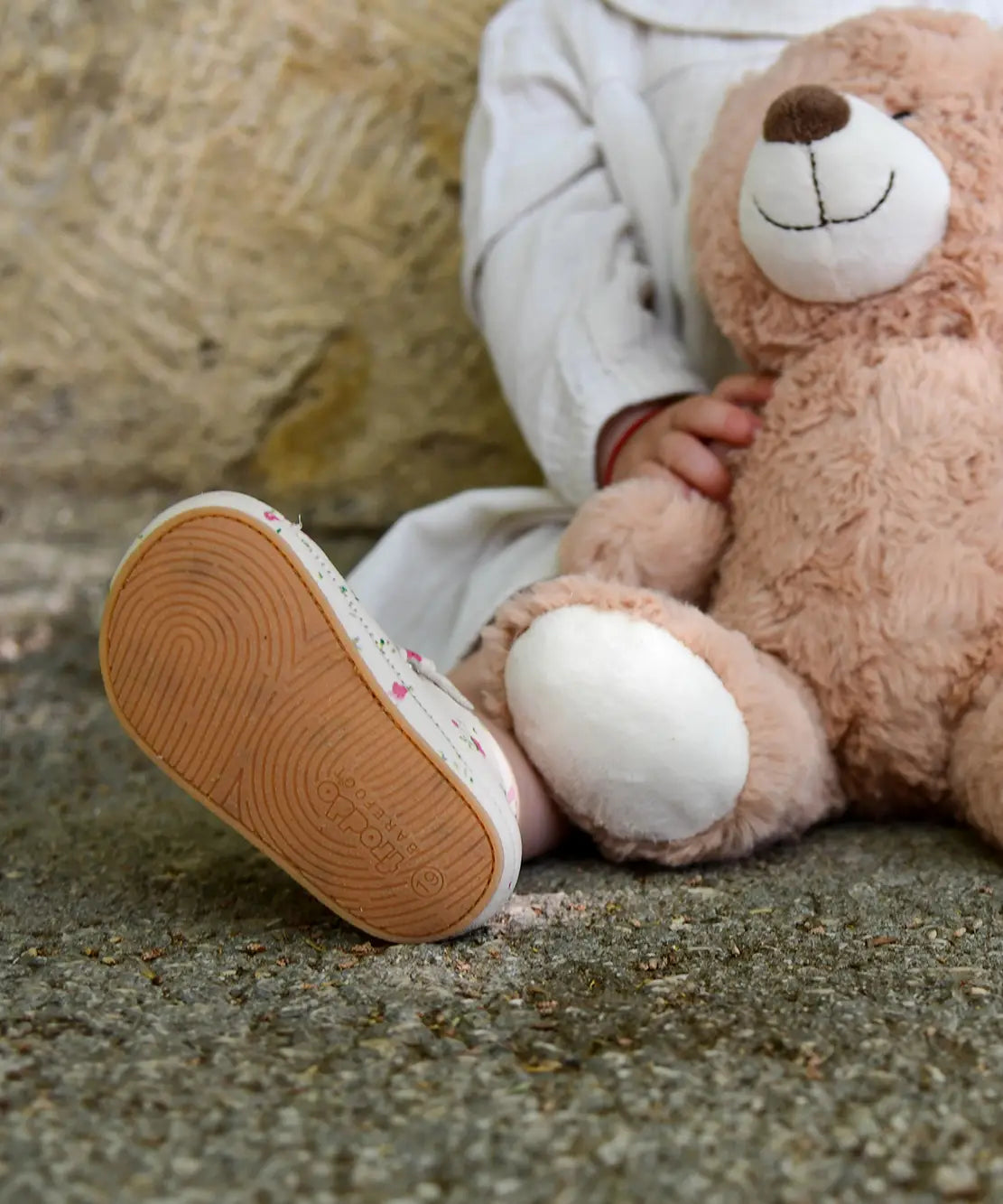 Close up of child wearing small child wearing Froddo's natural leather pre walker sandals showing rubber sole detail 