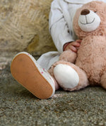 Close up of child wearing small child wearing Froddo's natural leather pre walker sandals showing rubber sole detail 