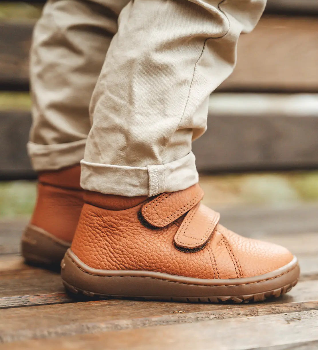 Child wearing Froddo's natural leather kids barefoot shoes. Boots have a flexible rubber sole and zero drop profile