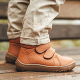 Child wearing Froddo's natural leather kids barefoot shoes. Boots have a flexible rubber sole and zero drop profile