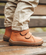 Child wearing Froddo's natural leather kids barefoot shoes. Boots have a flexible rubber sole and zero drop profile