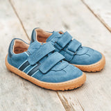 Pair of Froddo barefoot f-motion kids suede shoes in denim blue on decking. Sports trainer has a wide, foot shaped toe box and zero heel drop
