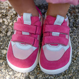 Small child wearing Froddo's barefoot zeru Spring kids shoes in light and dark pink showing front velcro straps fastened