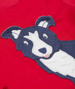 A close up of the Frugi kids adventure applique top berry red/sheepdog top showing the sheepdog applique detail on red organic cotton fabric.