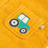 A closer look at the embroidered tractor on the pocket of the Frugi Adley Cord Dungarees - Gold/Tractor