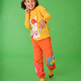Frugi adventure top with horse applique paired with pink jogger bottoms with floral design, worn by girl.